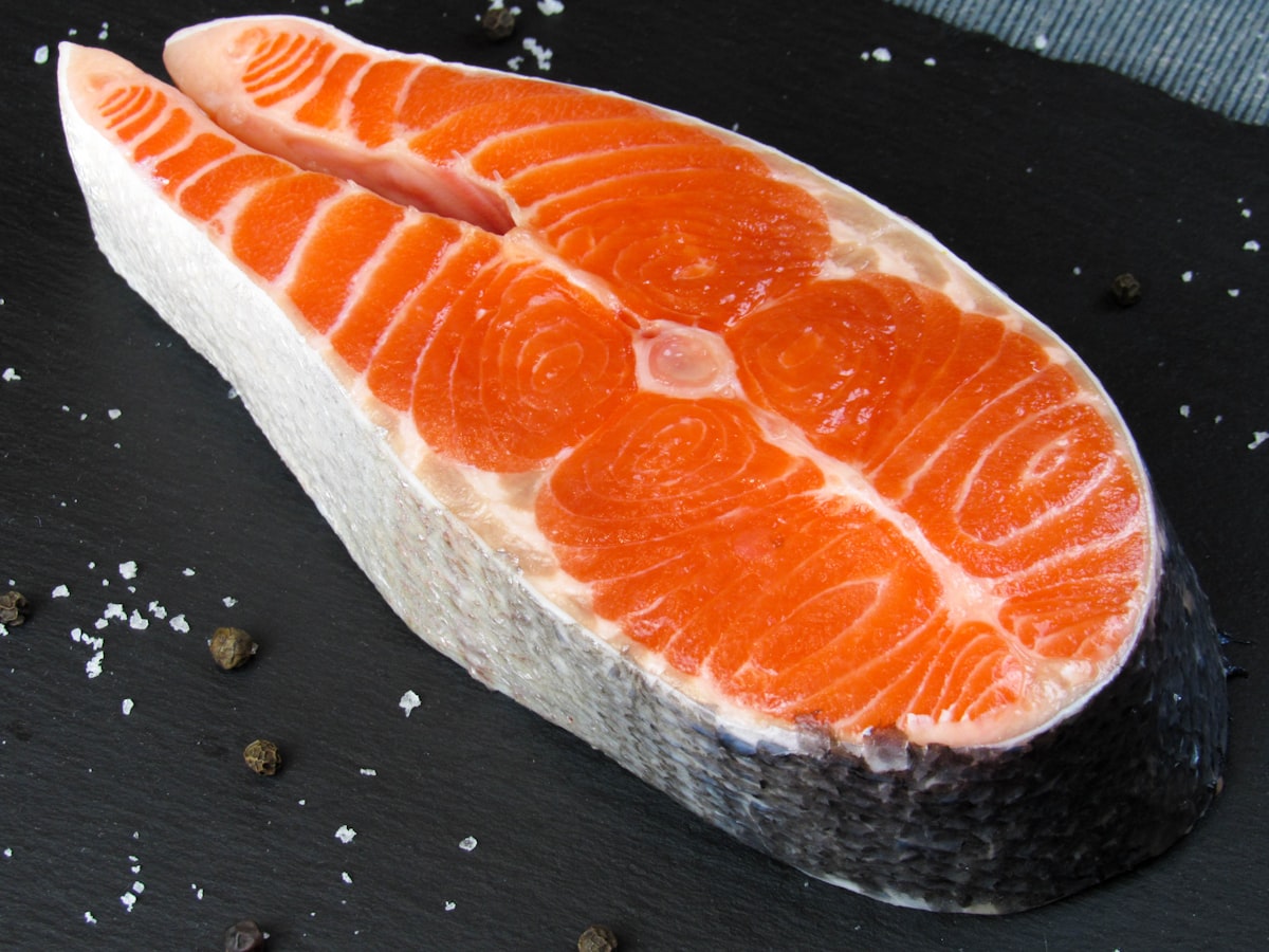 frisches rohes lachsfilet in nahaufnahme mit deutlicher rotoranger maserung fuer alphavital astaxanthin